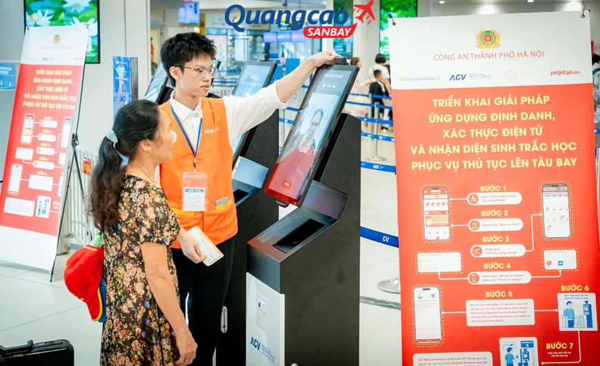 Nhân viên hàng không tại sân bay Nội Bài hỗ trợ hành khách sử dụng kiosk sinh trắc học